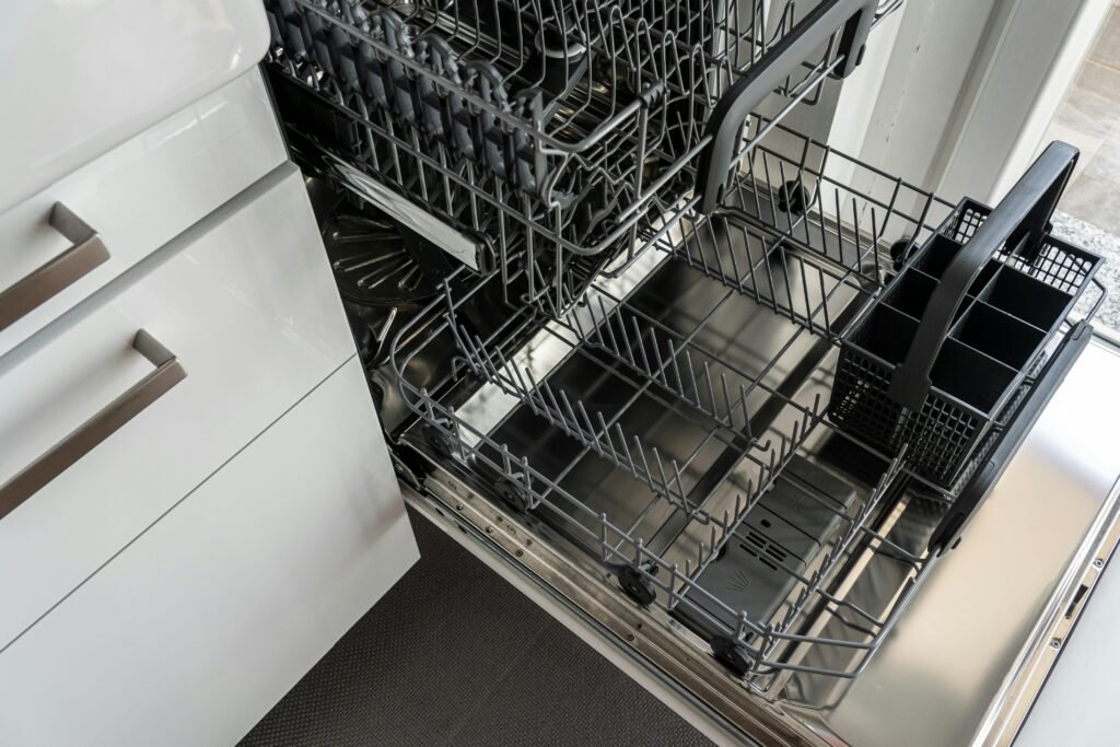A person cleaning the inside of a dishwasher, removing grime and food residue for better performance.