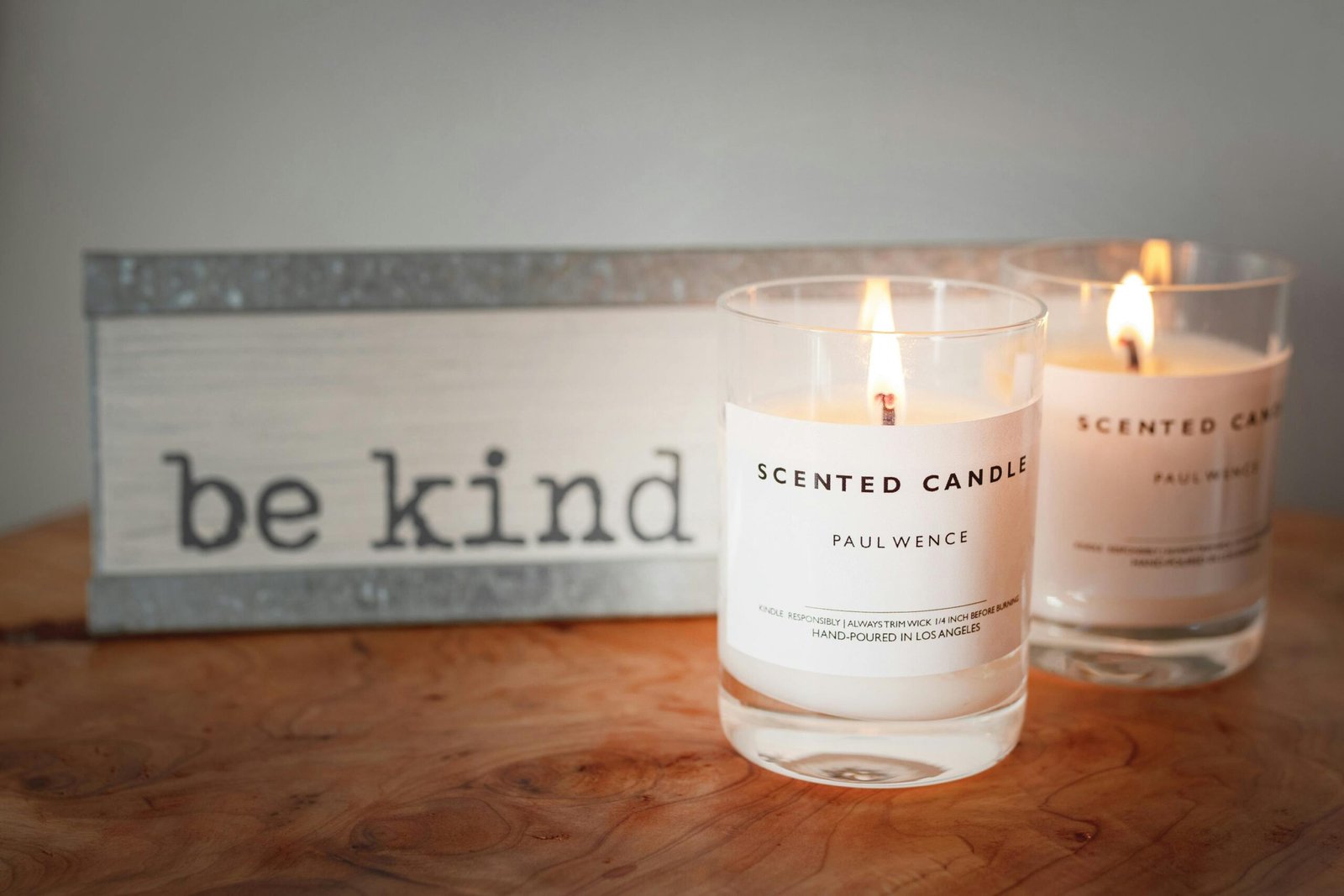 A lit candle burning on a clean table, filling the room with a calming scent.